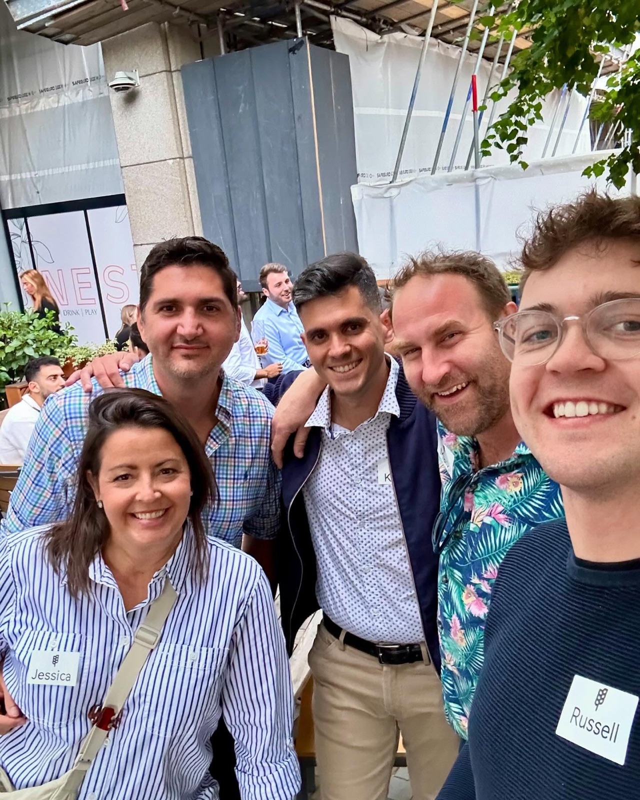 Members with name tags squeezed into a group selfie at a meetup