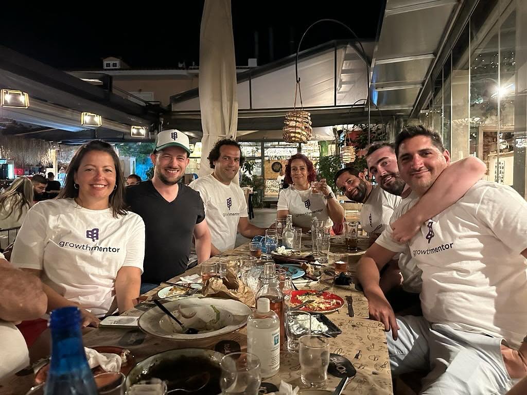 Members in GrowthMentor t-shirts at a taverna dinner