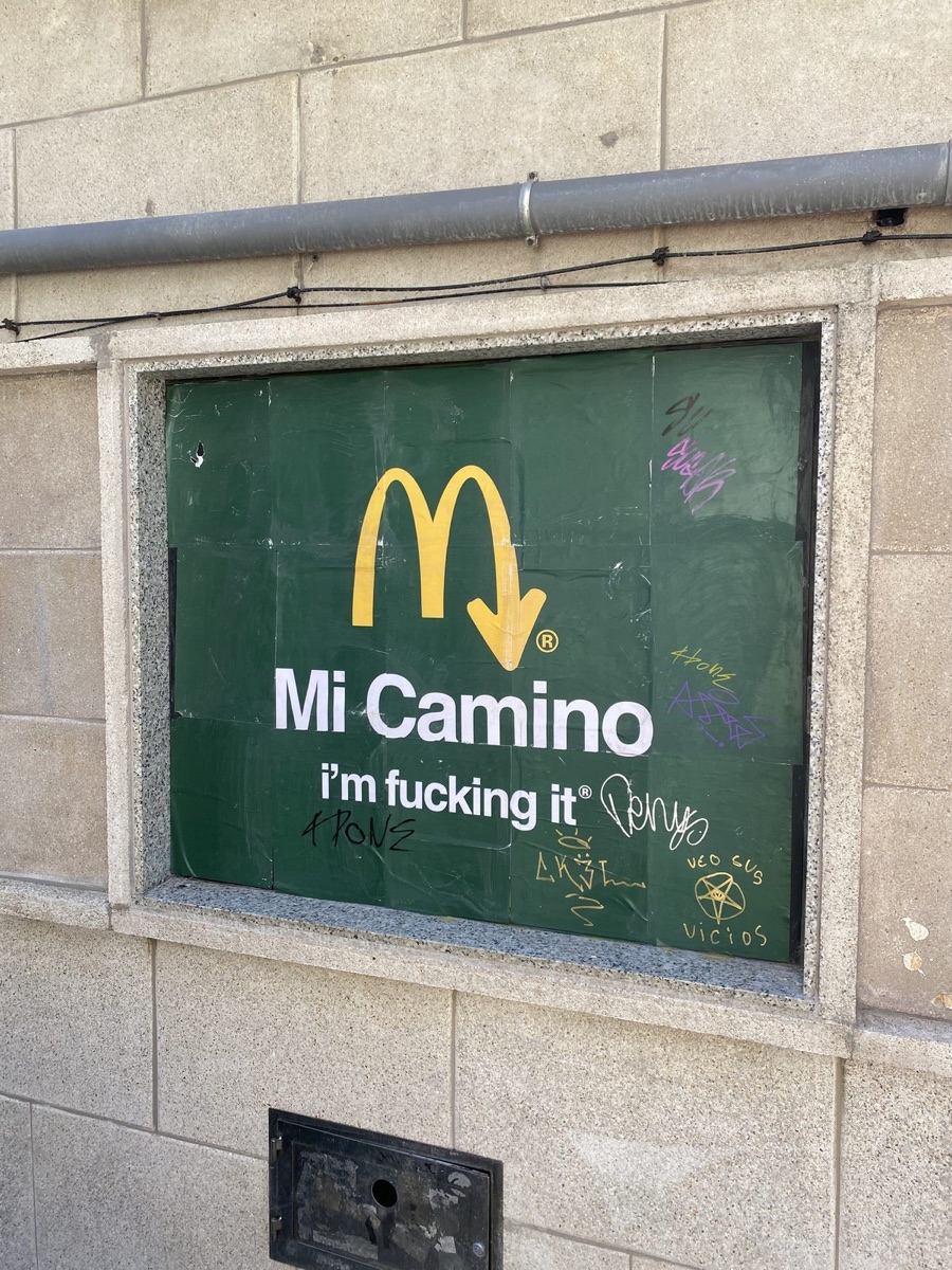A green McDonald's poster reading Mi Camino i'm f***ing it with the arch as an arrow